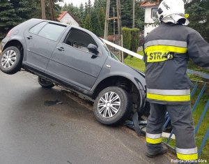 Pojazd VW Golf po zdarzeniu, uszkodzony obok strażak